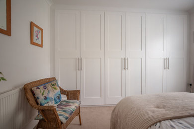 他の地域にある広いコンテンポラリースタイルのおしゃれな主寝室 (白い壁、カーペット敷き、ベージュの床)