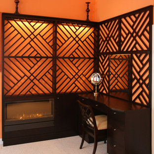 Imagen de habitación de invitados bohemia, de tamaño medio, con parades naranjas, moqueta, chimenea lineal, marco de chimenea de madera y suelo gris