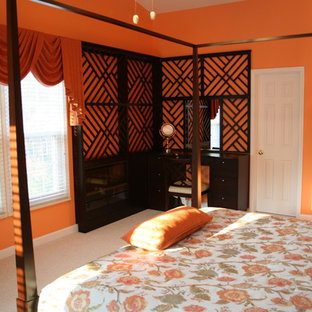 Foto de habitación de invitados ecléctica, de tamaño medio, con parades naranjas, moqueta, suelo gris, chimenea lineal y marco de chimenea de madera