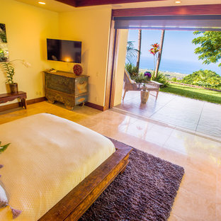 Diseño de dormitorio principal, tropical, de tamaño medio, con paredes beige y suelo de piedra caliza