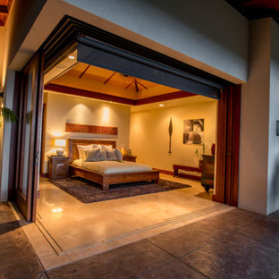 Foto de dormitorio principal, tropical, de tamaño medio, con paredes beige y suelo de piedra caliza