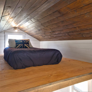Diseño de dormitorio tipo loft, costero, pequeño, sin chimenea, con paredes blancas y suelo de contrachapado