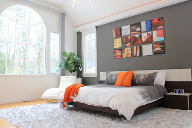 Diseño de dormitorio principal contemporáneo grande sin chimenea con suelo beige, paredes grises y suelo de madera en tonos medios