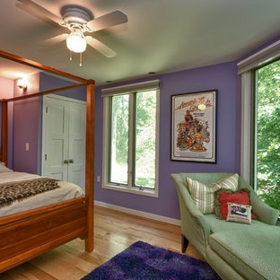 Foto de habitación de invitados moderna, de tamaño medio, sin chimenea, con paredes púrpuras y suelo de madera clara