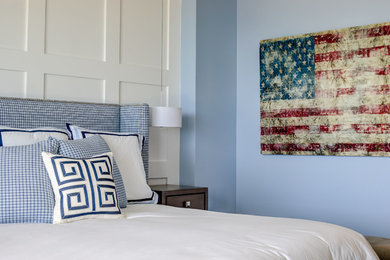 Modelo de dormitorio principal costero de tamaño medio con paredes azules, suelo de baldosas de porcelana y suelo beige