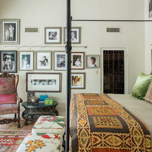 Modelo de dormitorio principal, bohemio, grande, con paredes beige y suelo de baldosas de terracota