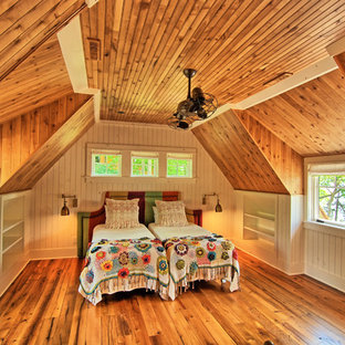 Imagen de dormitorio tipo loft, rural, grande, sin chimenea, con paredes beige y suelo de madera en tonos medios