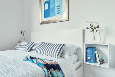 ダブリンにある中くらいなビーチスタイルのおしゃれな主寝室 (白い壁、淡色無垢フローリング)