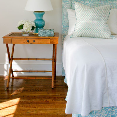Elegant medium tone wood floor bedroom photo in New York with white walls