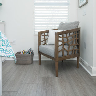 Modelo de habitación de invitados costera, de tamaño medio, con suelo vinílico y suelo gris