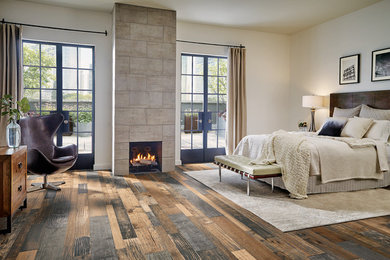 Mid-sized mountain style master medium tone wood floor and brown floor bedroom photo in Boston with beige walls, a standard fireplace and a tile fireplace