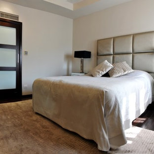 Ejemplo de dormitorio principal, contemporáneo, de tamaño medio, con paredes beige, suelo de contrachapado y suelo marrón