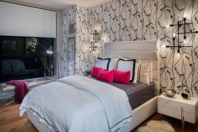 Diseño de dormitorio principal moderno grande con paredes grises y suelo de madera en tonos medios