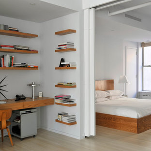 Idee per una camera da letto design con pareti bianche e parquet chiaro