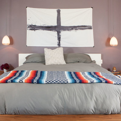 Example of a mid-sized trendy master medium tone wood floor bedroom design in Los Angeles with purple walls