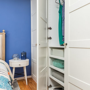 Imagen de habitación de invitados ecléctica, pequeña, sin chimenea, con paredes azules, suelo de madera clara y suelo naranja