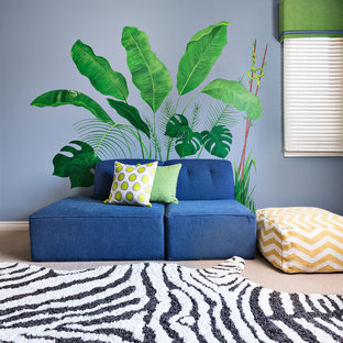 Imagen de dormitorio tipo loft, tropical, grande, sin chimenea, con paredes azules y moqueta