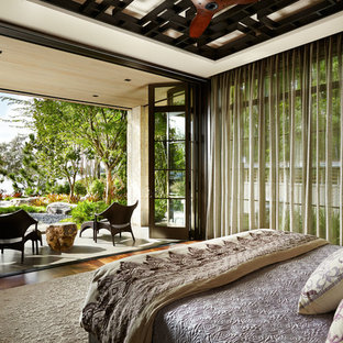 Inspiration pour une grand chambre parentale asiatique avec un sol en bois brun, un mur beige, aucune cheminée et un sol marron.