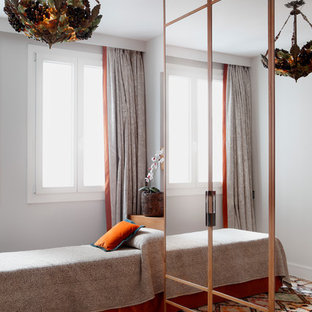 Foto de habitación de invitados mediterránea, de tamaño medio, sin chimenea, con paredes grises y suelo de madera en tonos medios