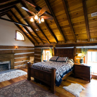 Foto de dormitorio abovedado y madera, rural, grande, madera, con paredes marrones, suelo de madera clara, chimenea tradicional, marco de chimenea de madera y madera