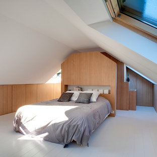 Exemple d'une grand chambre mansardée ou avec mezzanine tendance avec un mur blanc, un sol en bois peint et aucune cheminée.