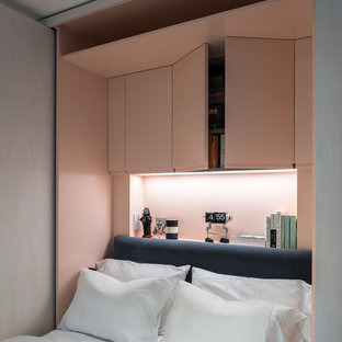 Modelo de dormitorio principal, moderno, pequeño, con paredes rosas y suelo de madera oscura
