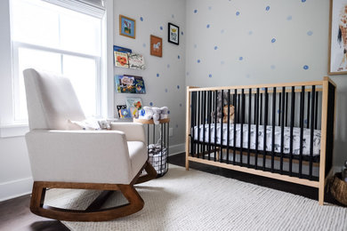 Foto de habitación de bebé moderna pequeña con paredes grises, suelo de madera oscura, suelo marrón y papel pintado