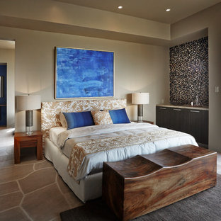 Imagen de dormitorio principal, de estilo americano, grande, con paredes beige, suelo de piedra caliza y suelo marrón