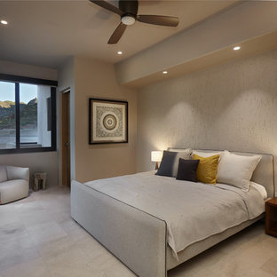 Diseño de habitación de invitados de estilo americano, grande, con paredes beige, suelo de baldosas de porcelana, marco de chimenea de hormigón y suelo gris
