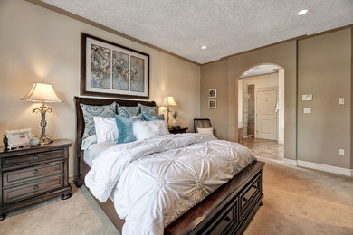 Example of a classic master carpeted and beige floor bedroom design in Calgary with brown walls