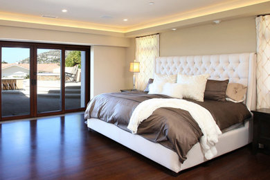 Imagen de dormitorio principal tradicional renovado de tamaño medio sin chimenea con paredes beige, suelo de madera oscura y suelo marrón