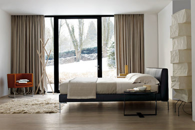 Großes Modernes Hauptschlafzimmer ohne Kamin mit weißer Wandfarbe, hellem Holzboden und beigem Boden in Calgary