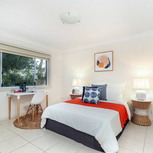 Inspiration for a beach style guest bedroom in Sydney with beige walls and beige floor.