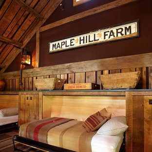 Example of a country guest medium tone wood floor bedroom design in New York with brown walls
