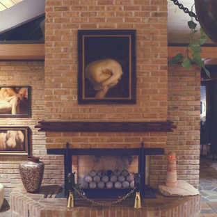 Modelo de dormitorio principal, moderno, extra grande, con paredes multicolor, suelo de ladrillo, chimenea tradicional y marco de chimenea de ladrillo