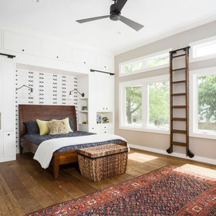 Foto de dormitorio principal, campestre, extra grande, sin chimenea, con paredes beige, suelo de madera en tonos medios, marco de chimenea de ladrillo y suelo marrón