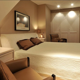 Foto de dormitorio principal, moderno, pequeño, con paredes beige, suelo de madera clara y suelo marrón