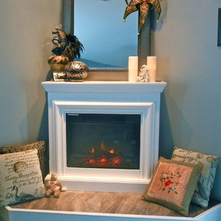 Imagen de dormitorio principal, tradicional, de tamaño medio, con paredes grises, suelo de baldosas de porcelana, chimenea de esquina y marco de chimenea de baldosas y/o azulejos
