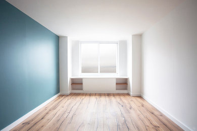 Diseño de dormitorio principal minimalista con suelo de madera clara