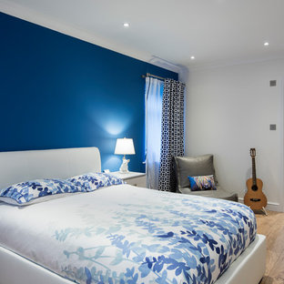 Medium sized contemporary bedroom in West Midlands with laminate floors, beige floors, blue walls and no fireplace.