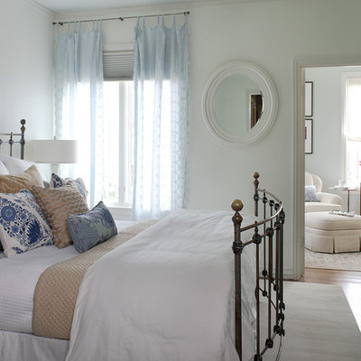 Elegant medium tone wood floor bedroom photo in San Francisco with white walls and no fireplace