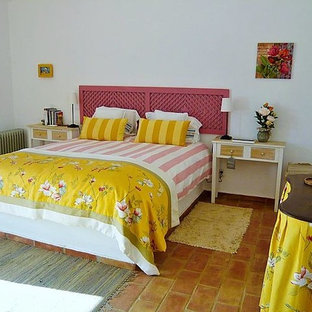 Modelo de dormitorio principal, marinero, grande, con paredes blancas y suelo de baldosas de terracota