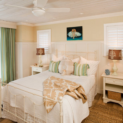Beach style master medium tone wood floor bedroom photo in Los Angeles with beige walls
