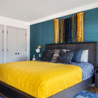 Imagen de habitación de invitados contemporánea, grande, sin chimenea, con paredes azules, suelo de madera clara y suelo beige
