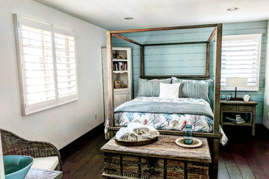 Foto de habitación de invitados costera de tamaño medio con paredes azules y suelo de madera clara