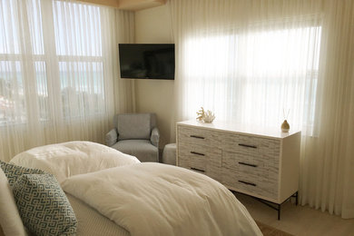 Modelo de dormitorio principal costero de tamaño medio con paredes blancas y suelo de baldosas de cerámica