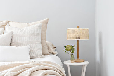 Foto de dormitorio principal costero de tamaño medio con paredes grises, suelo de madera clara y suelo beige