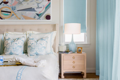 Diseño de dormitorio costero con paredes beige, suelo de madera en tonos medios y suelo marrón