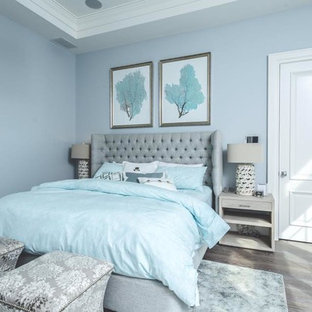 Foto de dormitorio principal, clásico renovado, grande, sin chimenea, con paredes azules, suelo de madera en tonos medios y suelo marrón