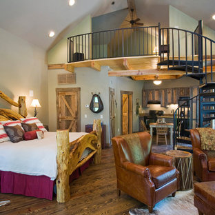 Imagen de dormitorio tipo loft, tradicional, de tamaño medio, sin chimenea, con paredes beige, suelo de madera en tonos medios y suelo marrón
